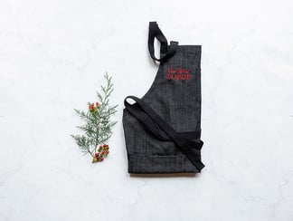 flat lay of a chefs apron next to christmas garland